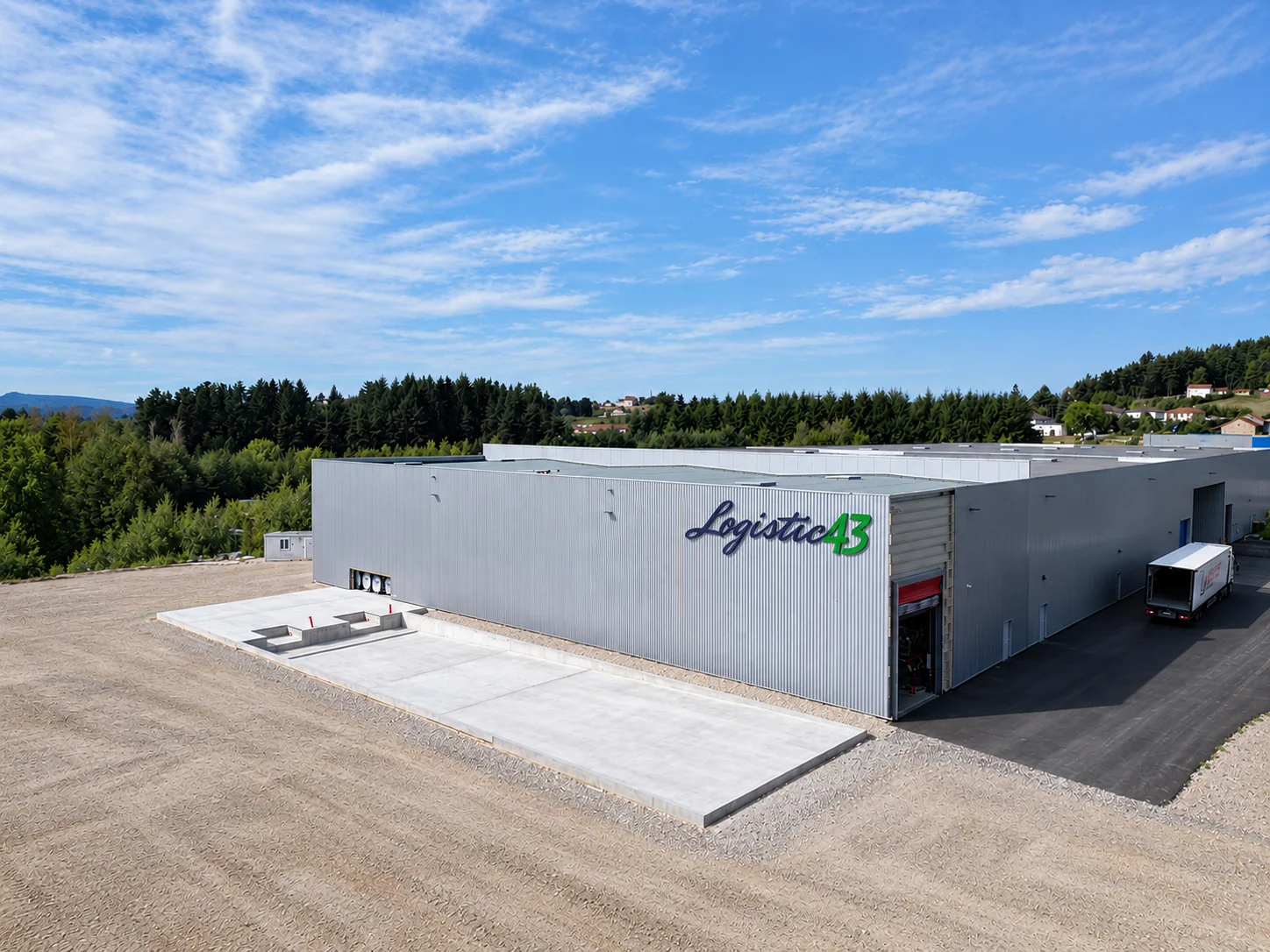 Terrassement et dalle béton de l'extension en construction devant l'entrepôt LOGISTIC 43 à Sainte-Sigolène
