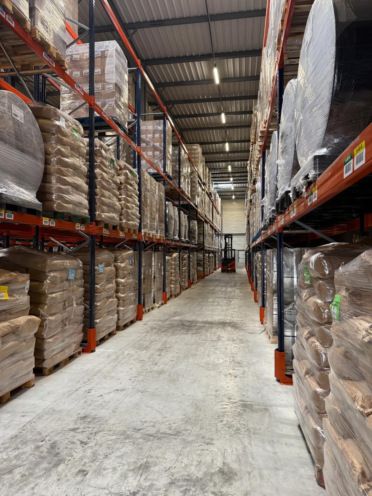 Chariot élévateur dans une allée de stockage palettisé chez LOGISTIC 43